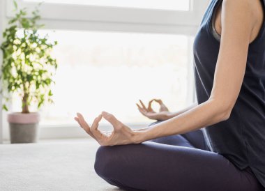 Evde yoga yapan genç bir kadın. 