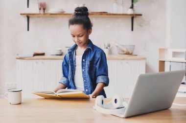 güzel şirin kız evde kitap okuyor, internet üzerinden eğitim görüyor, evde öğrenim görüyor, uzaklardan öğreniyor, ev ödevi yapıyor, liseli çocuk yaşam tarzı kavramı geliştiriyor.