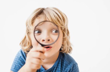 Büyüteçle mutlu şirin çocuk. 