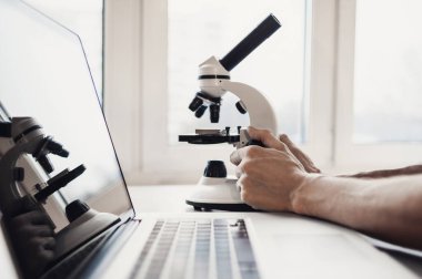 Masada mikroskop kullanan bir adam.