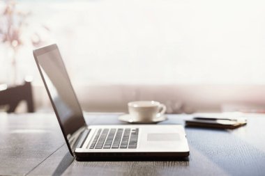 İş yeri, ev ofisi, dizüstü bilgisayar, defter, kahve fincanı, masadaki akıllı telefon. Evden çalışma, serbest çalışma, iş, uzaklık eğitimi, çevrimiçi öğrenme, öğrenim kavramı