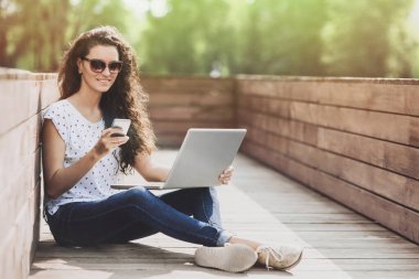 Genç kız açık havada akıllı telefon kullanıyor.