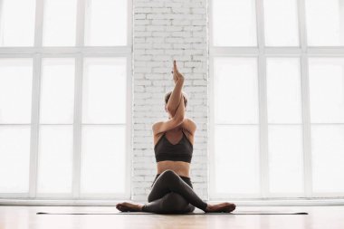 Genç bir kadın meditasyon yapıyor. Sınıfta yoga yapan bir kız. Rahatlama, vücut bakımı, meditasyon, denge, uyum, dinlenme konsepti