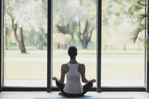 Young woman meditating at home. Girl practicing yoga in class. Relaxation, body care, meditation,balance, harmony, recreation concept