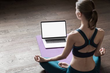Evde yoga yapan genç bir kadın. Çevrimiçi video eğitimi. Egzersiz ve meditasyon yapan bir kız. Yoga, denge, meditasyon, rahatlama, sağlıklı yaşam tarzı, online eğitim sınıfı konsepti.