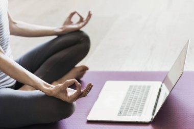 Evde yoga yapan genç bir kadın. Çevrimiçi video eğitimi. Egzersiz ve meditasyon yapan bir kız. Yoga, denge, meditasyon, rahatlama, sağlıklı yaşam tarzı, online eğitim sınıfı konsepti.