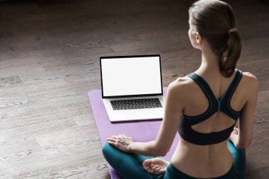 Evde yoga yapan genç bir kadın. Çevrimiçi video eğitimi. Egzersiz ve meditasyon yapan bir kız. Yoga, denge, meditasyon, rahatlama, sağlıklı yaşam tarzı, online eğitim sınıfı konsepti.