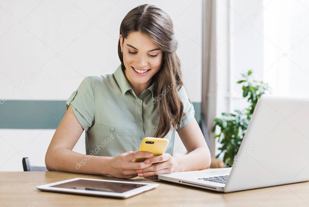 Business woman using laptop and smartphone in office. Student girl, entrepreneur, businesswoman, freelancer working on computer at home. Technology, home work, online learning, studying concept.