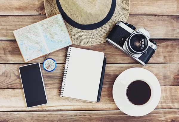 Accessories for travel. photo camera,  travel map, smartphone, notepad, hat, cup . Top view. Holidays and tourism concept