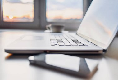 İş yeri, dizüstü bilgisayar ve cep telefonu ofis masasında ya da evde. İş, serbest meslek, teknoloji, işyeri, ev işi, çevrimiçi öğrenme, öğrenim kavramı. Uzaklık eğitimi