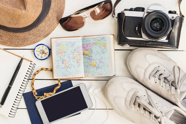 旅行のためのアクセサリー 木製の背景に異なるオブジェクト パスポート 写真カメラ スマートフォン サングラス 電子ブックリーダー 最上階だ 休日と観光の概念 — ストック写真