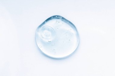 Kozmetik krem şeffaf sıvı jel. Beyaz arkaplanda mavi leke