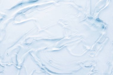 Kozmetik krem şeffaf sıvı jel. Beyaz arkaplanda mavi leke