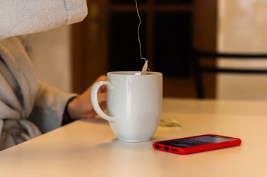 Enfüzyonu olan ve telefonu masada olan bir kız.