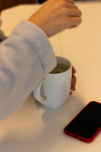 Enfüzyonu olan ve telefonu masada olan bir kız.