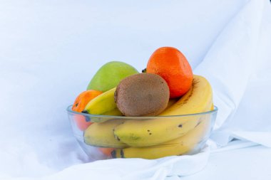 Beyaz arka planda bir kase farklı meyve