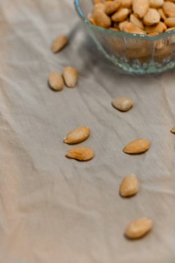 Gri arka planda bir kase kızarmış badem.