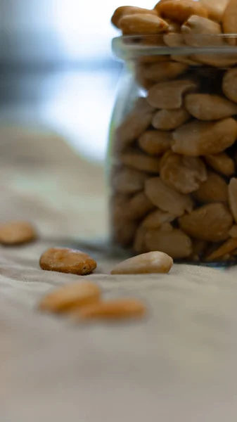 Gri arka planda bir kase kızarmış badem.