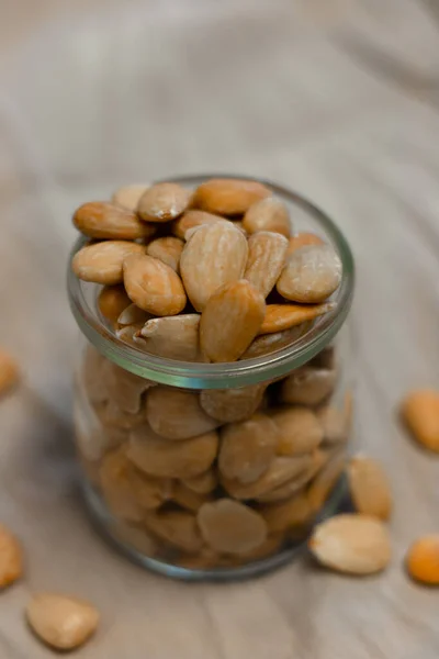 Gri arka planda bir kase kızarmış badem.