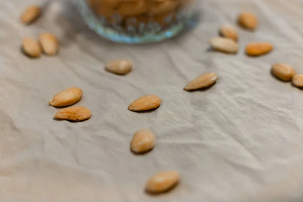 Gri arka planda bir kase kızarmış badem.