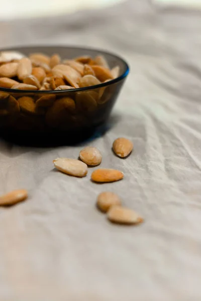 Gri arka planda bir kase kızarmış badem.