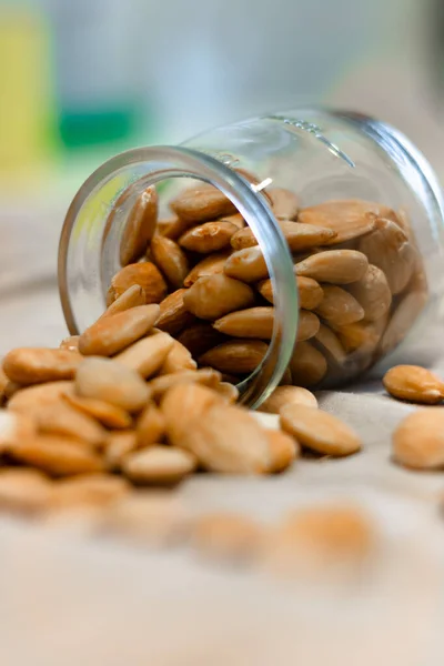 Gri arka planda bir kase kızarmış badem.