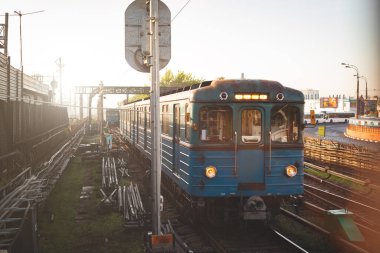 Eski bir metro treni istasyondan şehirdeki platforma hareket eder..