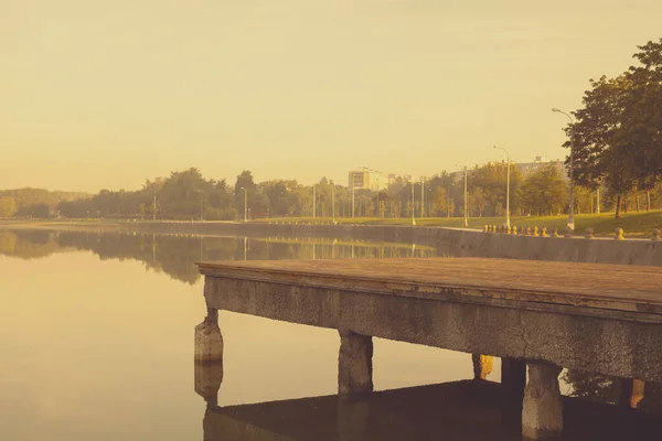 Şehir parkındaki gölette bir iskele. Renkli fotoğraf.