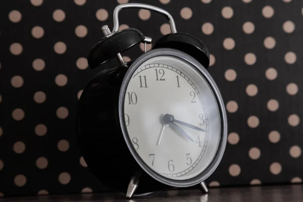 Clock alarm stands on a dark background.