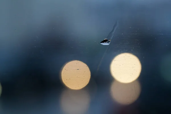 Yağmur damlalarıyla ıslak cam zemin ve Bokeh ile bulanık zemin. Mavi yeşil renk.