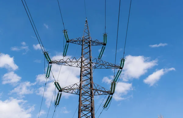 Bulutlu mavi gökyüzüne karşı yüksek voltajlı güç direkleri
