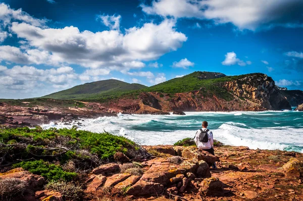 Adam sahilde bakarken sırt çantası ile