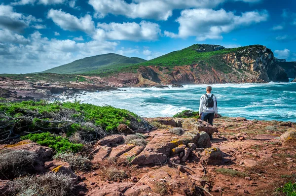 Adam sahilde bakarken sırt çantası ile