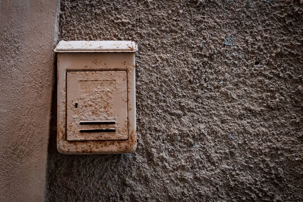 Old rusty mailbox on a rustic wall — Stock Photo, Image