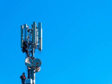 İşçiler anten üzerinde çalışıyor.