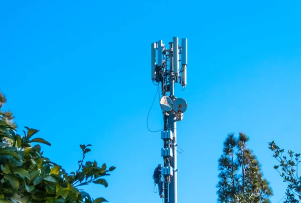 Trabajadores que trabajan en una antena Fotos de stock