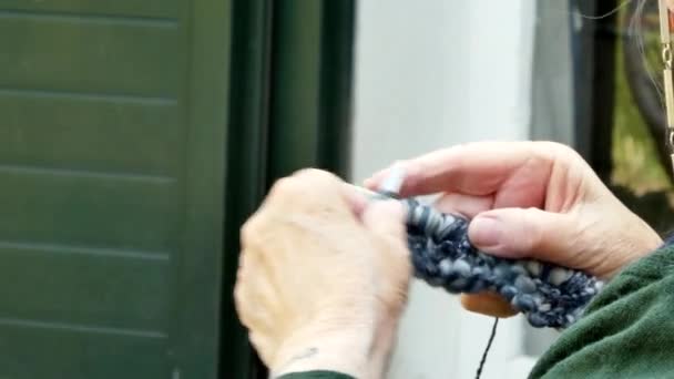 テラスで編み物をする老婦人の手を閉じて — ストック動画
