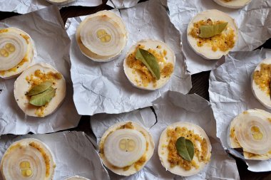 Camembert turşuya hazır, dilimlenmiş peynir, baharat ve soğanla kaplı..