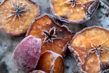 Kirli bir tabakta yarım kırmızı elma. Yaşlı, renkli, buzla kaplı. Bir elmanın çekirdeğindeki yıldız.