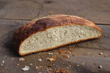 Kahverengi çıtır çıtır ekmekli ev yapımı ekmek, ikiye bölünmüş, ahşap masa kırıntıları..