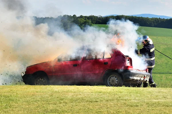 Strażak Gasi Pożar Samochodu Czerwony Samochód Ogniu Dym Strażak Wypadek Zdjęcie Stockowe