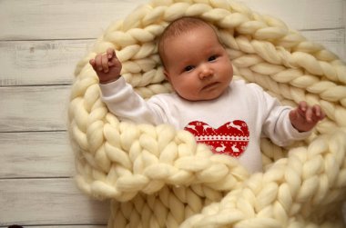 Küçük çocuk bir battaniyeye kalın iplik. Noel tema. Mutlu Sevgililer günü