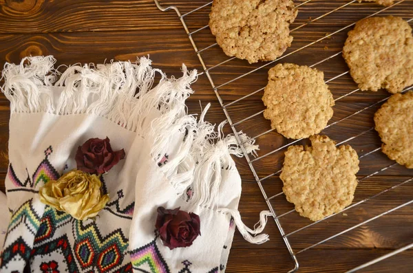 homemade oatmeal cookies on the table. Oatmeal cookies with splash of sunflower seeds, sesame seeds and raisin fresh from oven. Homemade oatmeal cookies folded in a pile on the old table