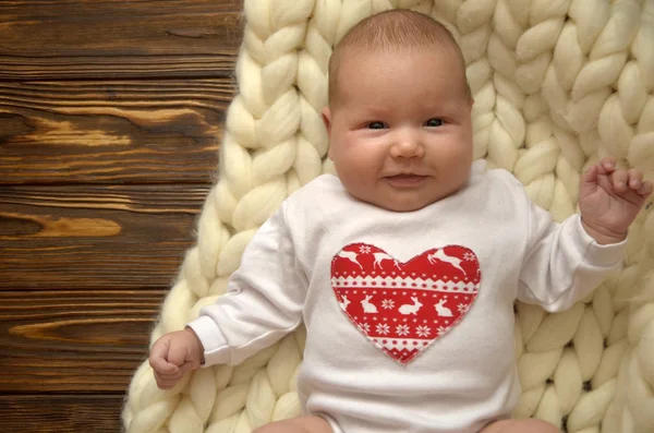 Small child in a blanket of thick yarn. Christmas theme. Happy Valentines Day — Stock Photo, Image