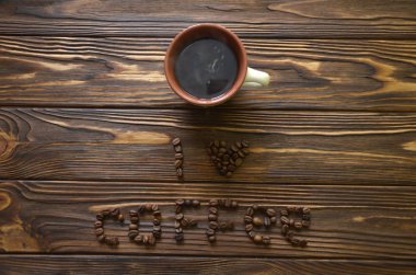 Kahve çekirdekleri tarafından ahşap bir masa üzerinde yazılı kahve seviyorum. Kahve kahve çekirdekleri ile masaya yazılı.