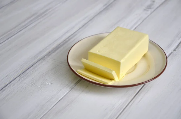 Beurre frais tranché sur la table en bois — Photo