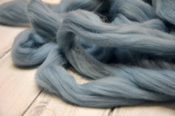 Μερινός μαλλί μπάλες, ξαπλωμένος στο ξύλινο τραπέζι, μπλε κλωστή — Φωτογραφία Αρχείου