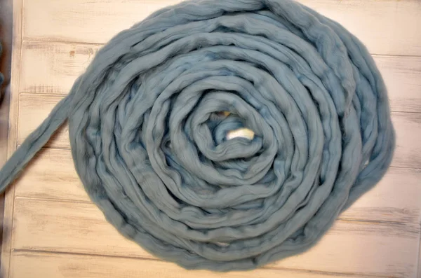 Merino wool balls, lying on wooden table, blue thread — Stock Photo, Image