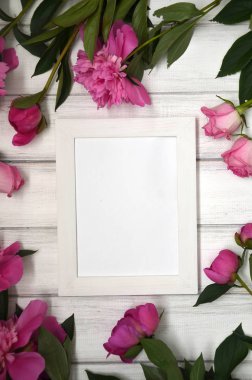 Beyaz rustik ahşap zemin üzerinde pembe peonies çarpıcı. Uzay kopyalayın. Resim veya fotoğraf için beyaz çerçeve