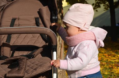 parkta gülerek mutlu Bebek arabasındaki bebek görünüyor